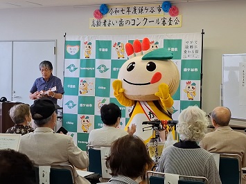 ウクレレを弾く歯医者さんと踊るかまたんの写真