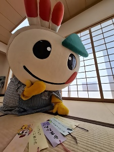 願い事を書いた5枚の短冊を見つめるかまたんの写真