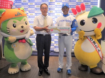 監督に梨を贈呈する梨業組合長と、なしこまどん、かまたんの写真