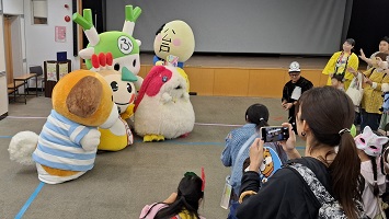 お客さん達に囲まれ写真を撮られるキャラクター達の写真