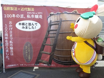 かまたんほどもある大きな木桶のパネルと並ぶかまたんの写真