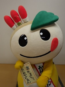 「あけましておめでとたん」の書き初めを手に持つかまたんの写真