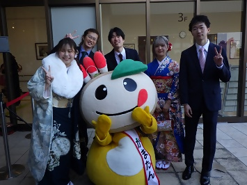 参加者達に囲まれるかまたんの写真