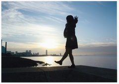 海沿いを歩く女性の写真