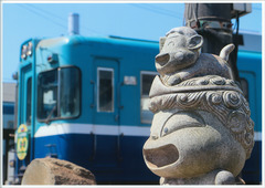 石像の傍を電車が通る写真