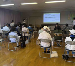 参加者の皆さんが、座って講演を聞いている写真