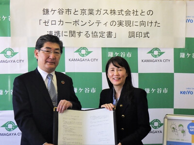 協定書を手にする京葉ガス株式会社の江口代表取締役社長（左）と芝田市長（写真）