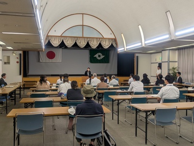 報告会で挨拶をする芝田市長（写真）