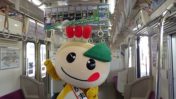 鎌ケ谷ラッピング車両内を紹介するかまたんの写真