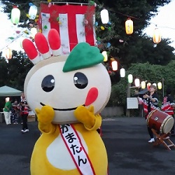 やぐら、太鼓の前にいるかまたんの写真