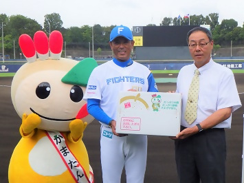 梨業組合長から稲葉監督へ梨を贈呈している写真