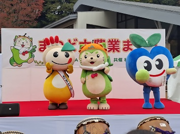 ステージに並ぶみのりちゃん、なしこまどん、かまたんの写真