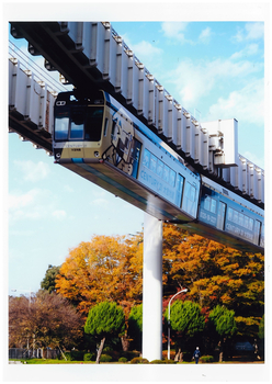 スポーツセンター駅付近で、紅葉と青空を背景に千葉都市モノレールが走っている様子の写真