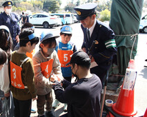 手錠のかけ方を体験している様子（写真）