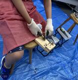 刃物を使用し、枝を削っている様子の写真