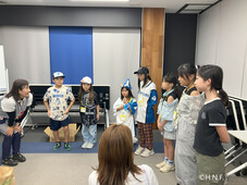 子どもたちが幼稚園の先生から話を聞いている様子(写真)