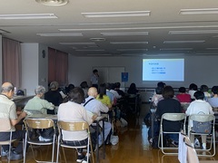 参加者の皆さんが座って講演を聞いている写真