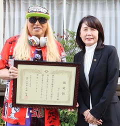 芝田市長と、こーさんが賞状を手に持っている写真