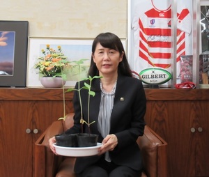 苗を持つ芝田市長（写真）