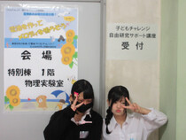 高校生2人が受付をしている風景（写真）